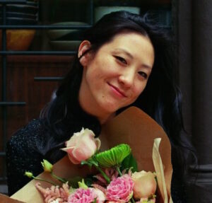 Image description: a photo of Allison park smiling and holding a bouquet of flowers